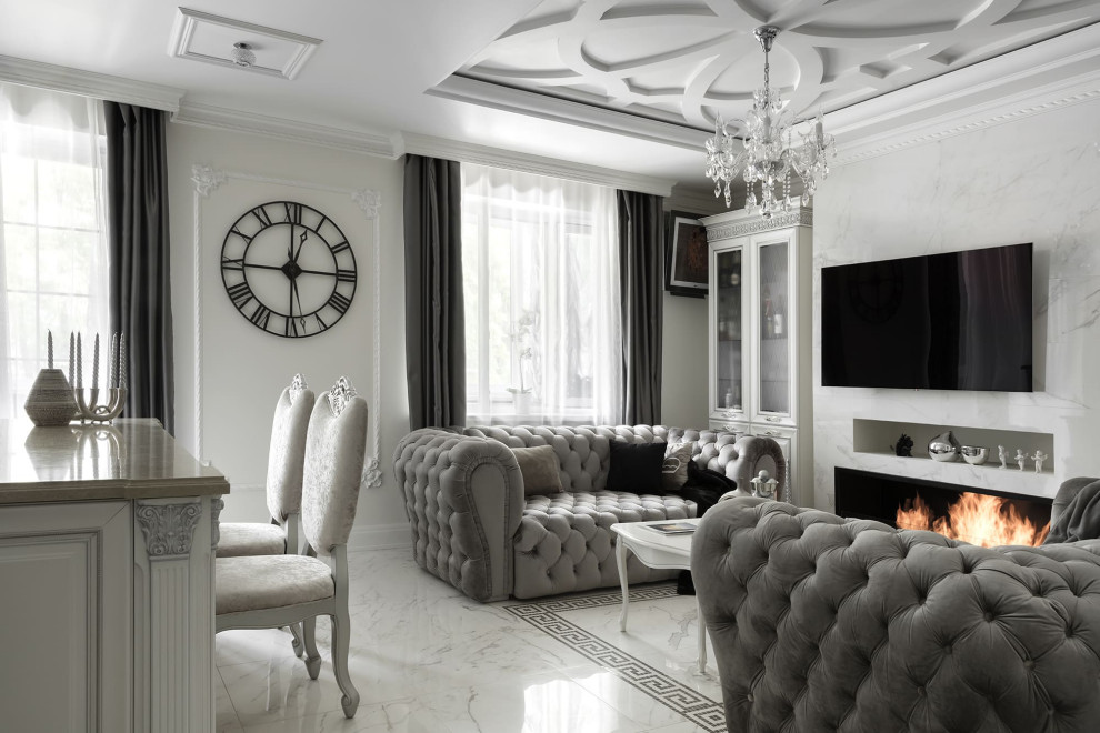 Стильный дизайн: большая парадная, открытая гостиная комната в классическом стиле с белыми стенами, полом из керамогранита, горизонтальным камином, фасадом камина из плитки, телевизором на стене и белым полом - последний тренд