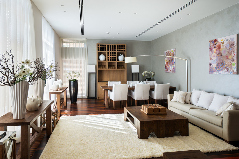Пример оригинального дизайна: гостиная комната в современном стиле с серыми стенами, темным паркетным полом и зоной отдыха