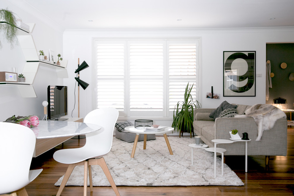 Idéer för att renovera ett minimalistiskt allrum med öppen planlösning, med vita väggar, en fristående TV och mörkt trägolv