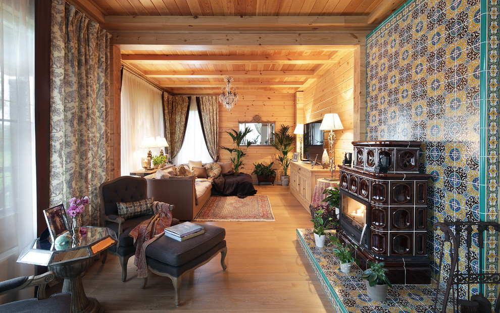 Immagine di un soggiorno country con pareti marroni, parquet chiaro, camino classico, cornice del camino piastrellata e pavimento beige