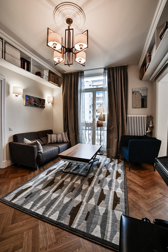 Kleines, Offenes Skandinavisches Musikzimmer ohne Kamin mit weißer Wandfarbe, braunem Holzboden, verstecktem TV und braunem Boden in Moskau