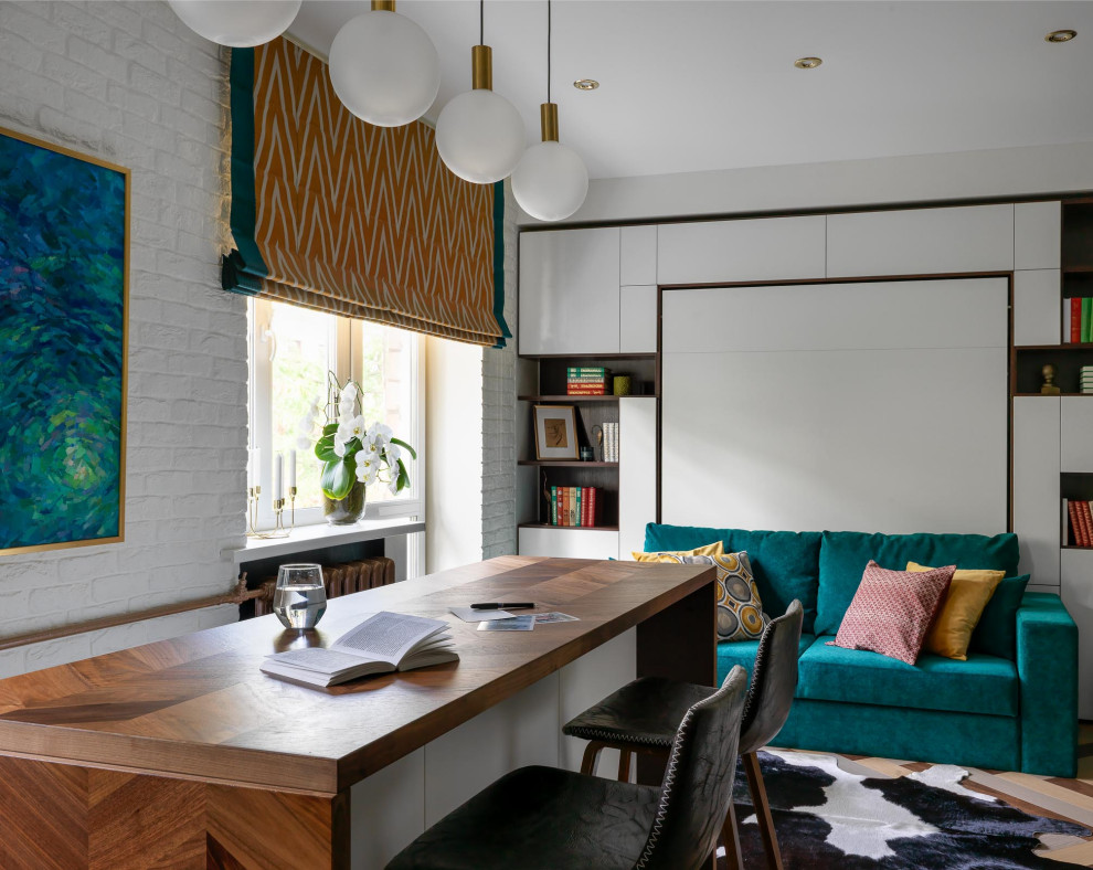 Стильный дизайн: маленькая открытая гостиная комната в современном стиле с белыми стенами, паркетным полом среднего тона, разноцветным полом и кирпичными стенами для на участке и в саду - последний тренд