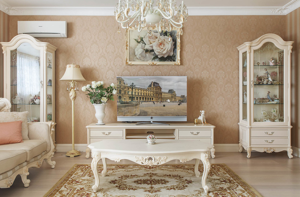 Ejemplo de salón para visitas abierto tradicional con paredes beige, suelo de madera clara y televisor independiente