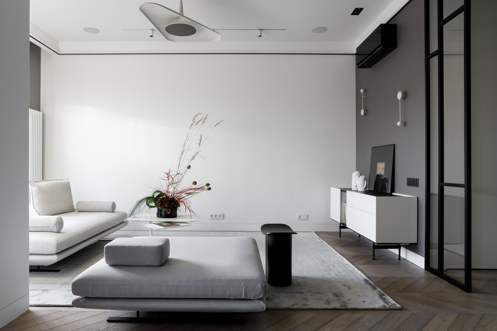 На фото: открытая гостиная комната среднего размера в современном стиле с белыми стенами, паркетным полом среднего тона и коричневым полом