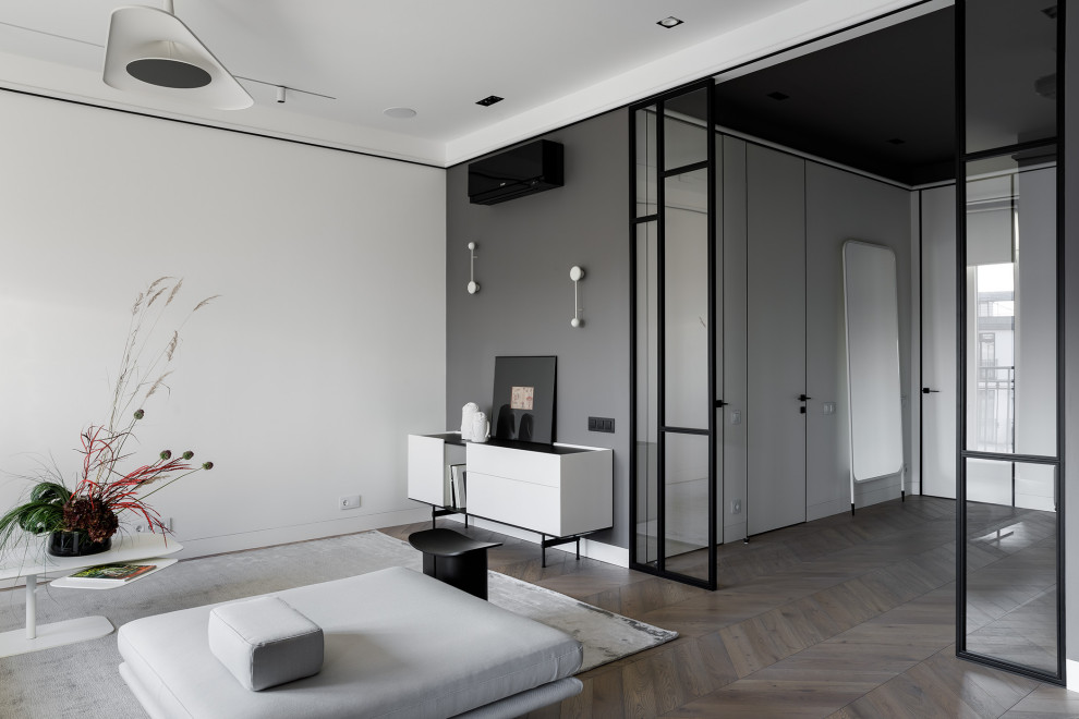 Diseño de salón abierto actual de tamaño medio con paredes blancas, suelo de madera en tonos medios y suelo marrón