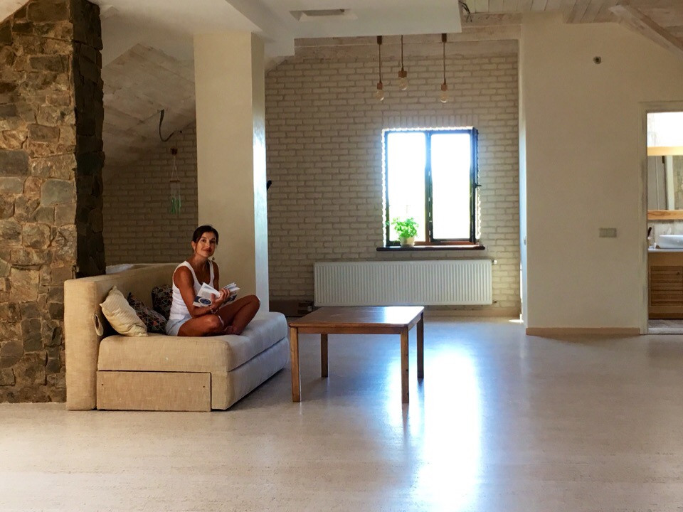 На фото: большая гостиная комната в стиле рустика с бежевыми стенами, пробковым полом и бежевым полом с