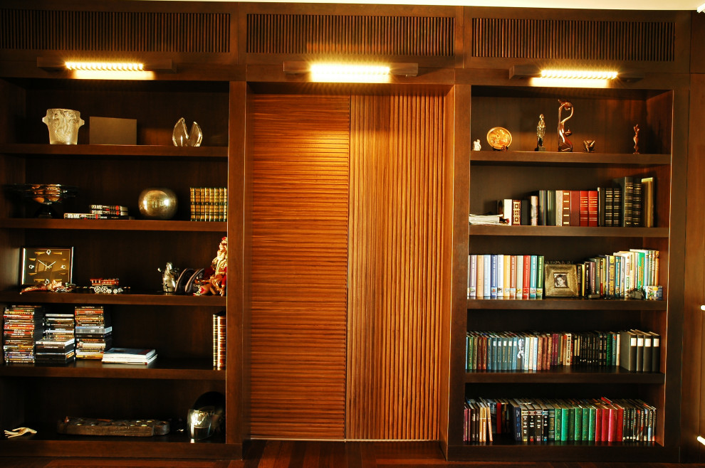 Идея дизайна: большая открытая гостиная комната в стиле фьюжн с с книжными шкафами и полками, бежевыми стенами, темным паркетным полом, скрытым телевизором и коричневым полом