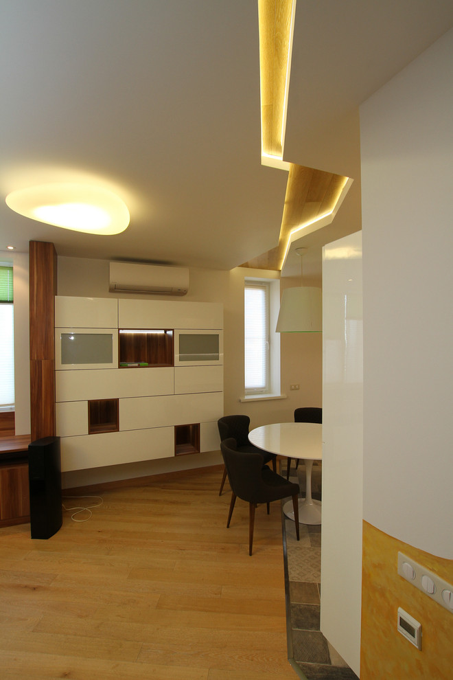 Foto de salón con barra de bar abierto actual grande con paredes blancas, suelo de madera clara y televisor colgado en la pared