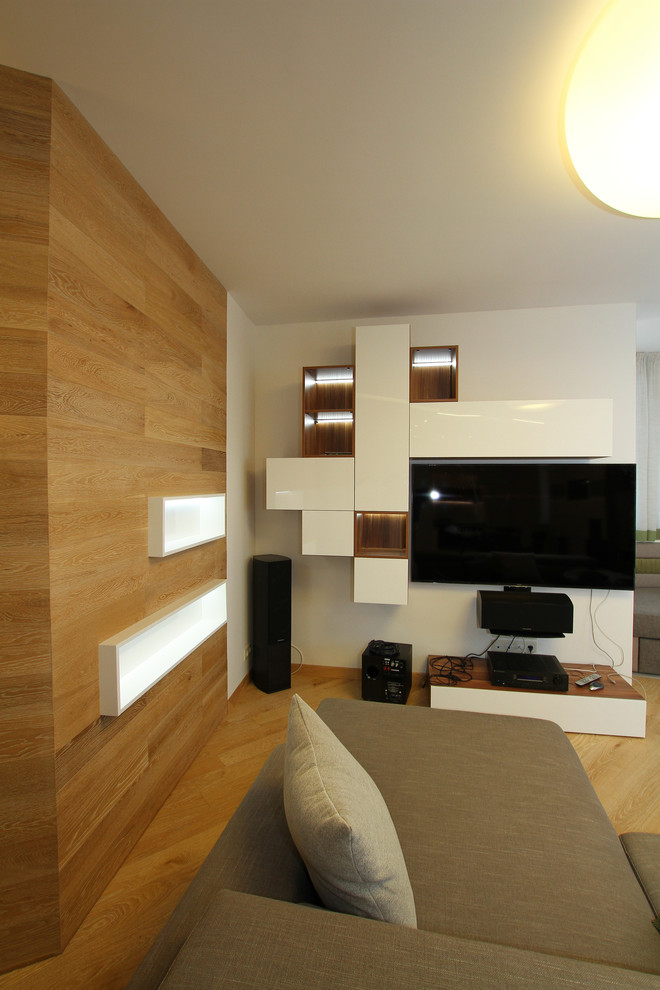 На фото: большая гостиная комната в современном стиле с музыкальной комнатой, белыми стенами, светлым паркетным полом и телевизором на стене без камина