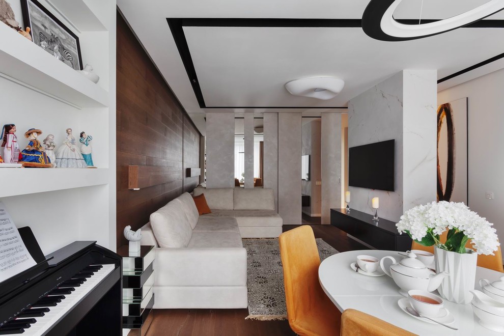 Пример оригинального дизайна: открытая, объединенная гостиная комната среднего размера в современном стиле с белыми стенами, паркетным полом среднего тона, телевизором на стене и коричневым полом