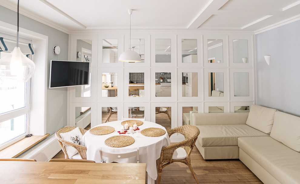 Источник вдохновения для домашнего уюта: открытая, объединенная гостиная комната в скандинавском стиле с паркетным полом среднего тона и телевизором на стене
