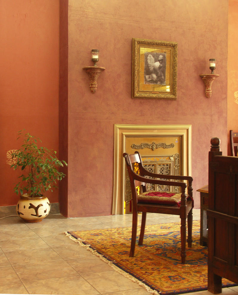 Идея дизайна: маленькая изолированная гостиная комната в восточном стиле с оранжевыми стенами, полом из керамогранита, стандартным камином, фасадом камина из металла и бежевым полом без телевизора для на участке и в саду