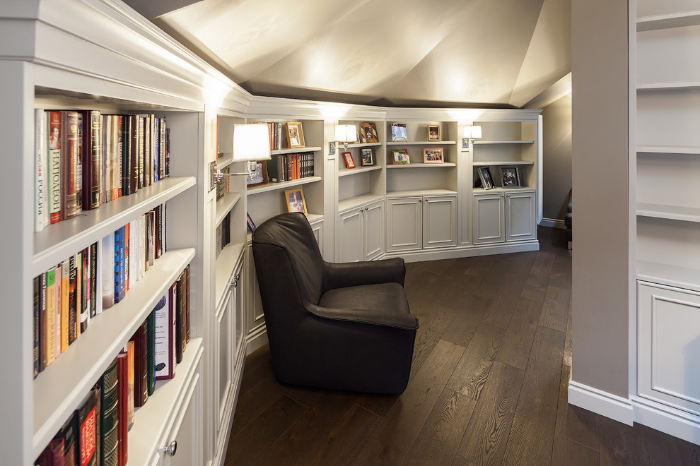 Imagen de sala de estar con biblioteca tradicional de tamaño medio con paredes grises y suelo de madera oscura