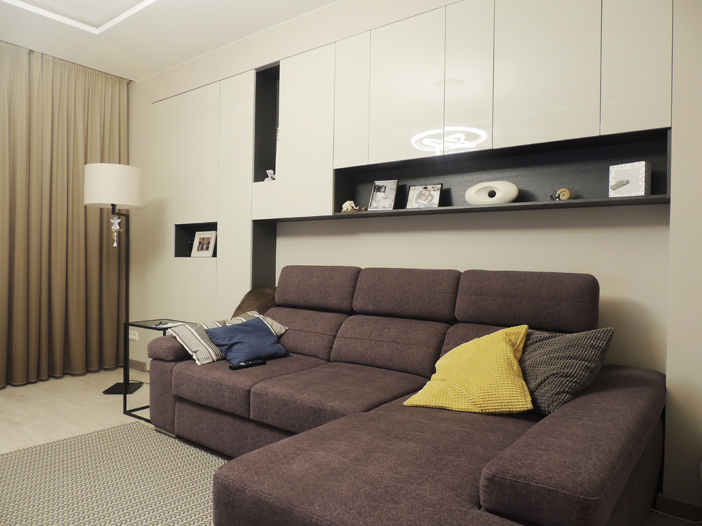 Foto de salón cerrado contemporáneo de tamaño medio con paredes beige, suelo laminado, televisor independiente y suelo beige