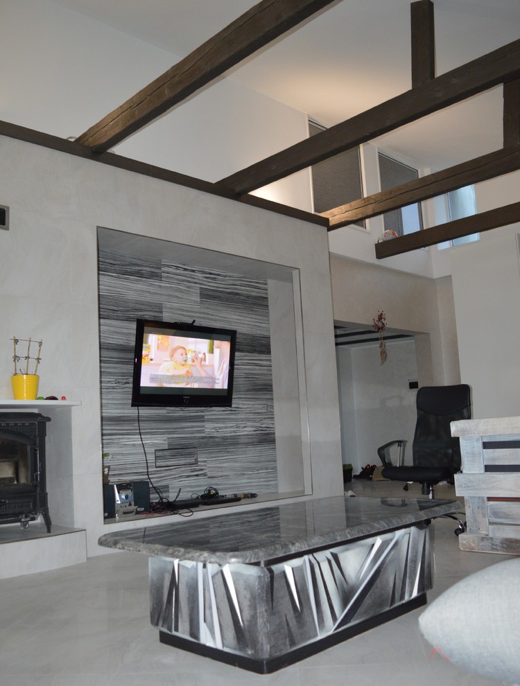 На фото: парадная, двухуровневая гостиная комната среднего размера в стиле лофт с белыми стенами, полом из керамогранита, печью-буржуйкой, фасадом камина из металла, телевизором на стене и серым полом с