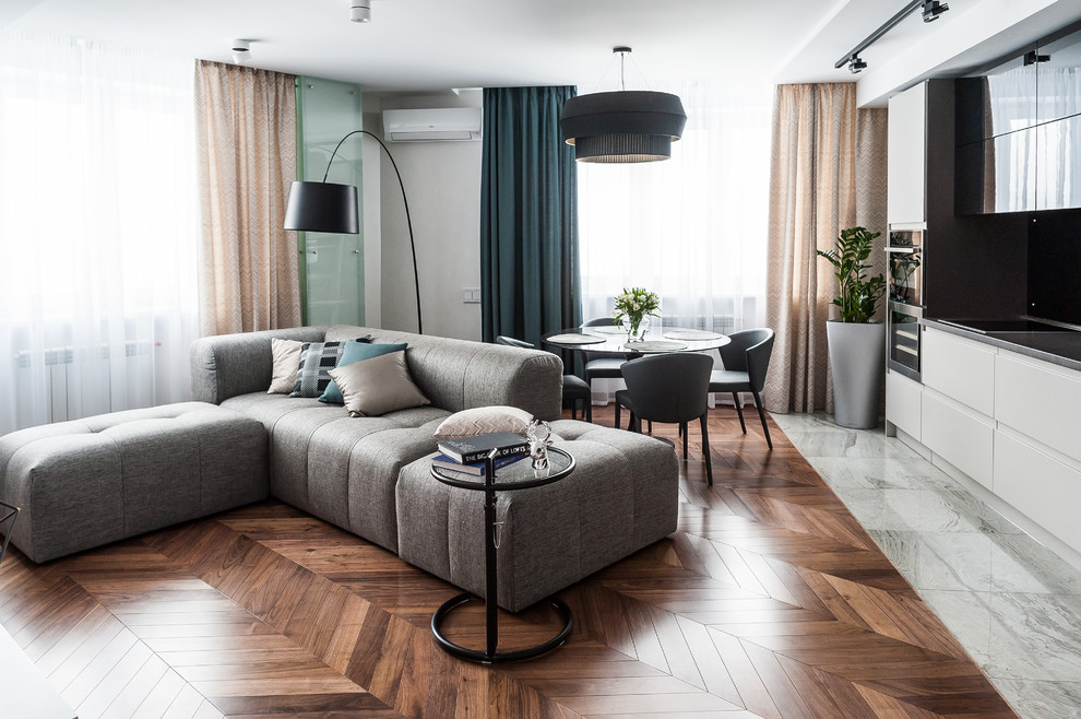 Esempio di un soggiorno design aperto con sala formale, pareti bianche, pavimento in legno massello medio e pavimento marrone