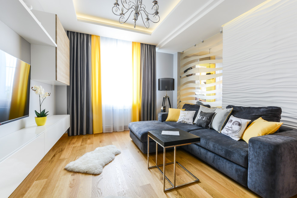 Exemple d'une salle de séjour tendance de taille moyenne et fermée avec un sol en bois brun, un téléviseur fixé au mur et un mur blanc.