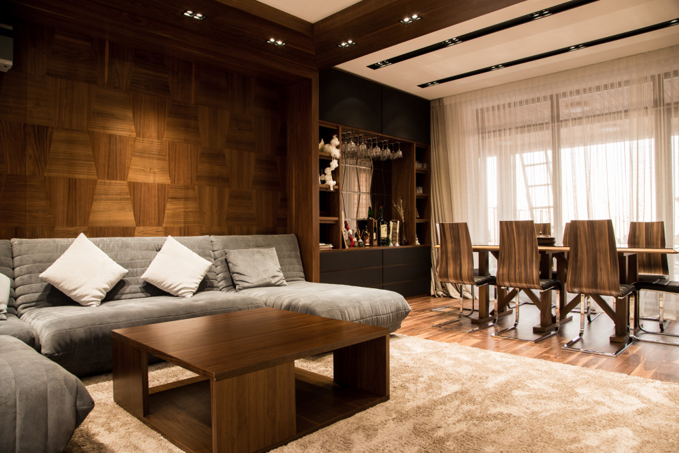 Стильный дизайн: гостиная комната в современном стиле с коричневыми стенами, темным паркетным полом и коричневым полом - последний тренд