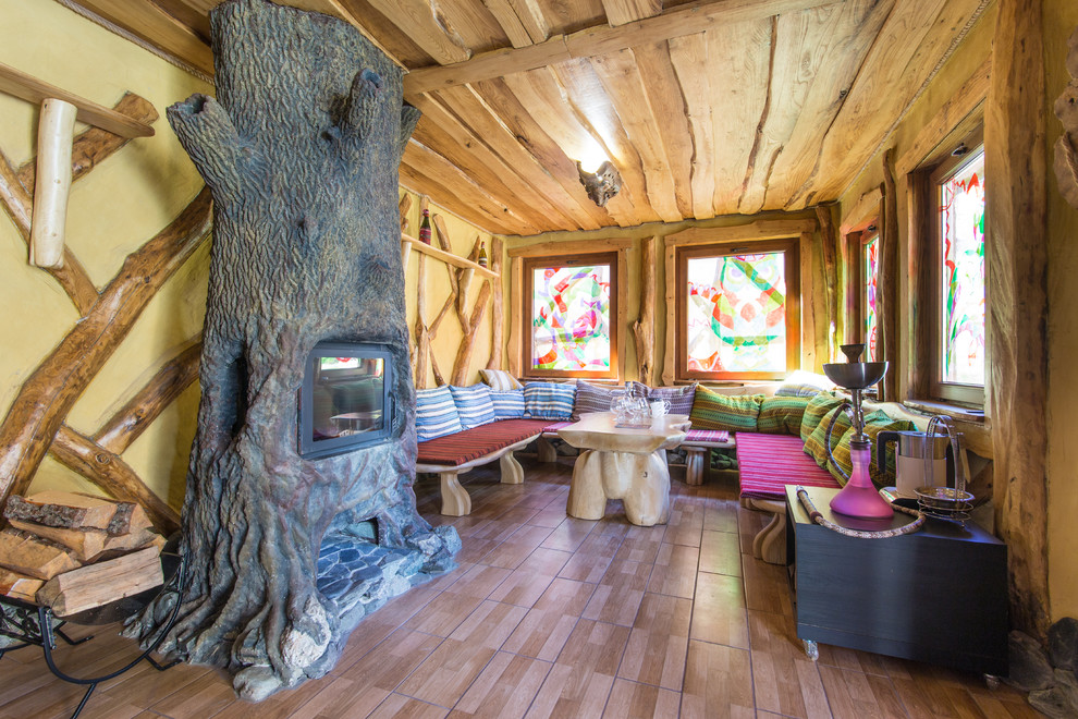 Photo of a rustic living room in Other with brown walls and a standard fireplace.