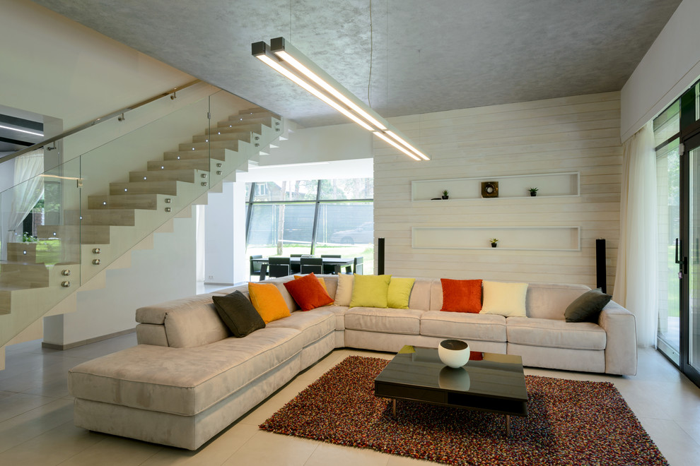 Imagen de salón abierto contemporáneo con paredes blancas, suelo de baldosas de porcelana, chimenea lineal, marco de chimenea de metal y televisor colgado en la pared