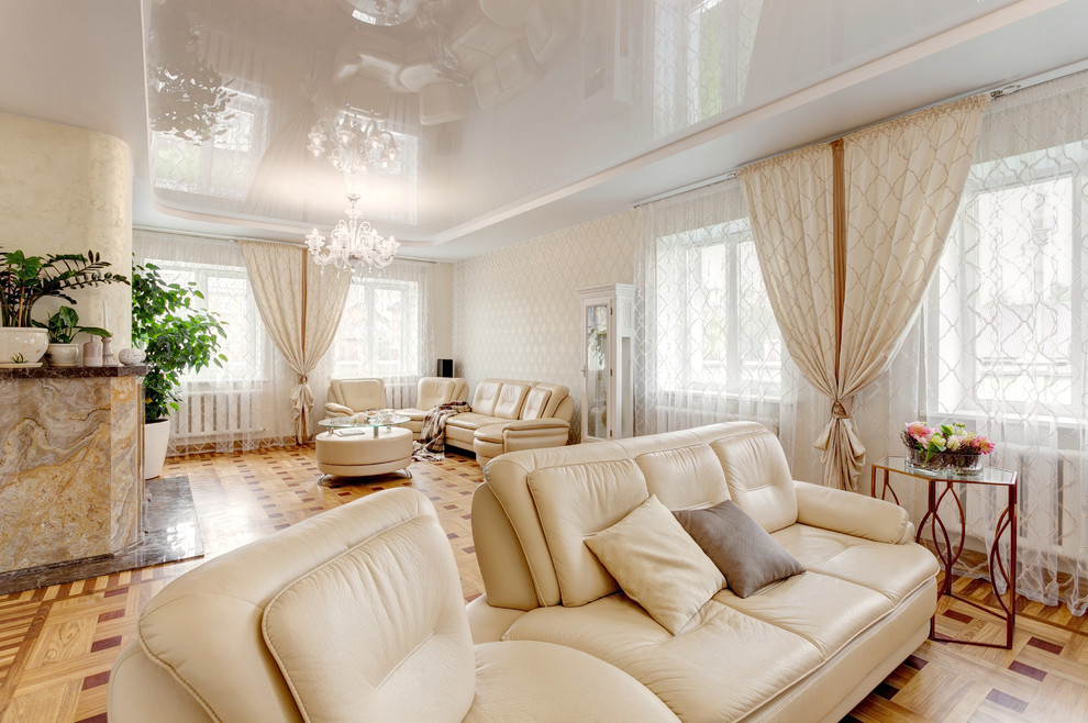 Abgetrenntes Klassisches Wohnzimmer mit beiger Wandfarbe, braunem Holzboden, Kamin und Kaminumrandung aus Stein in Sonstige