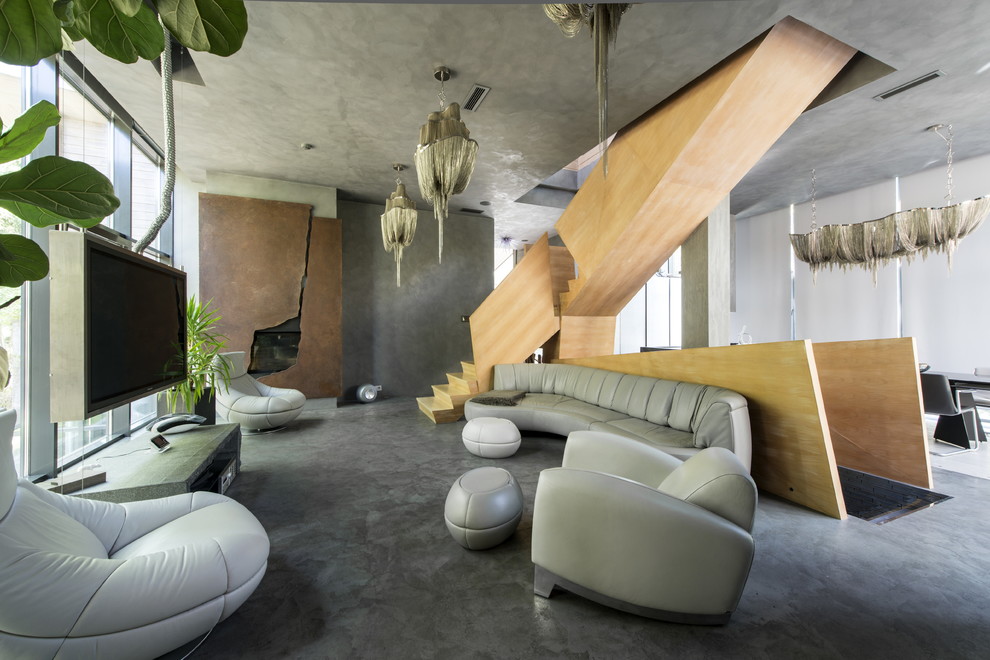 Immagine di un grande soggiorno minimal aperto con pareti grigie, pavimento in cemento, camino classico, cornice del camino in metallo e TV autoportante