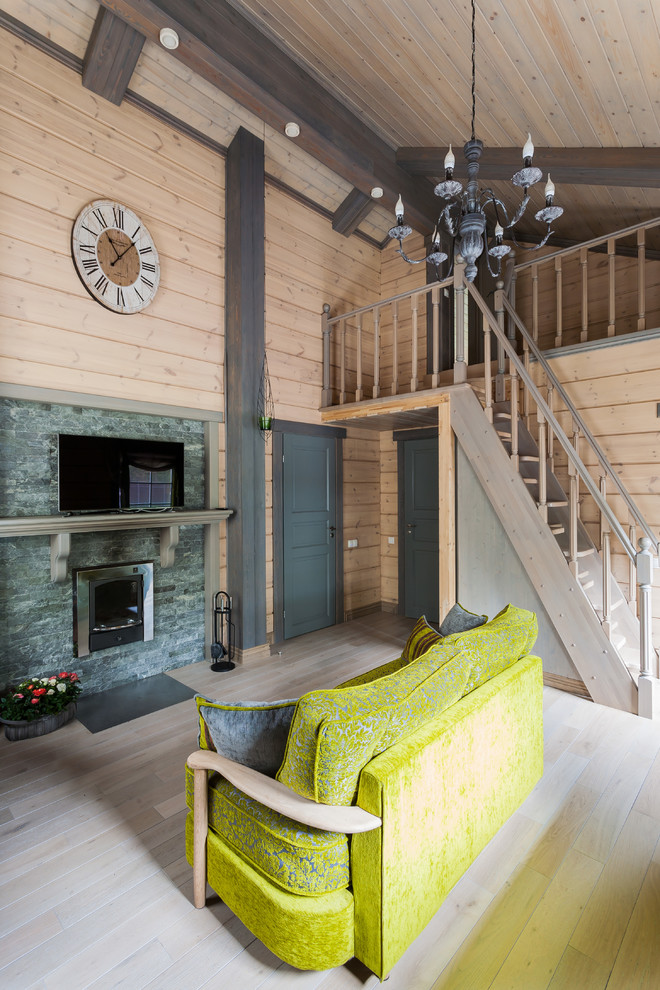 Diseño de salón para visitas abierto de estilo de casa de campo con paredes beige, suelo de madera clara, todas las chimeneas, marco de chimenea de piedra y televisor independiente