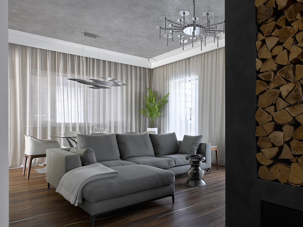 Aménagement d'un salon contemporain avec un mur gris, parquet foncé et un sol marron.