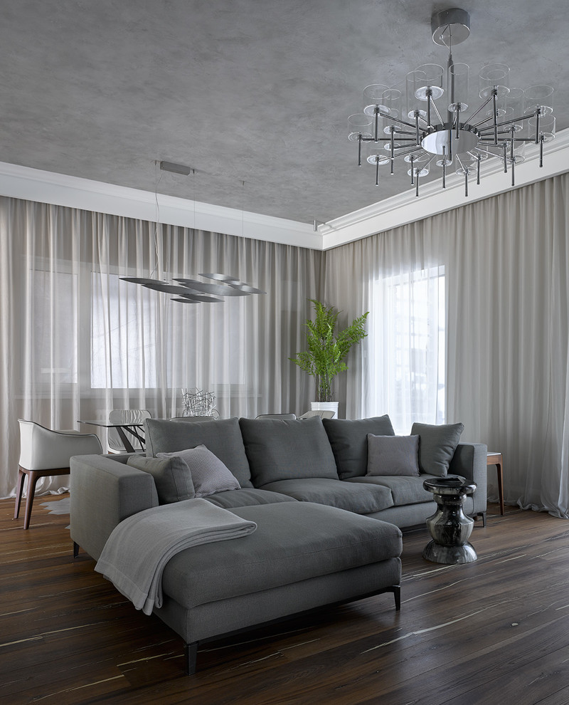 Пример оригинального дизайна: гостиная комната в современном стиле с серыми стенами, темным паркетным полом и коричневым полом