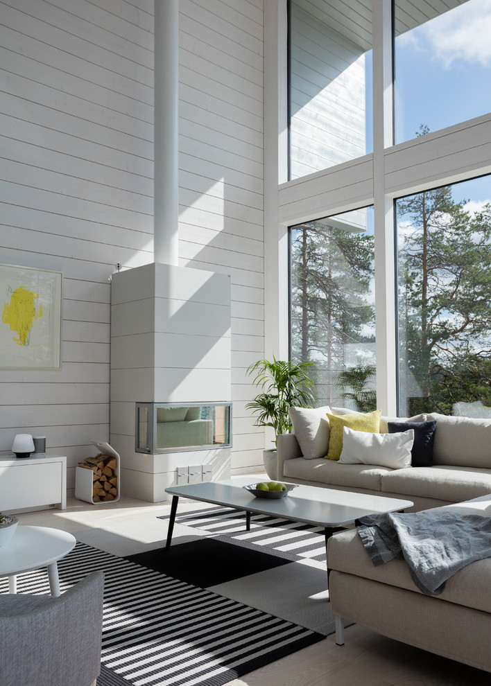 Immagine di un soggiorno costiero aperto con sala formale, parquet chiaro, pavimento beige, pareti bianche e stufa a legna