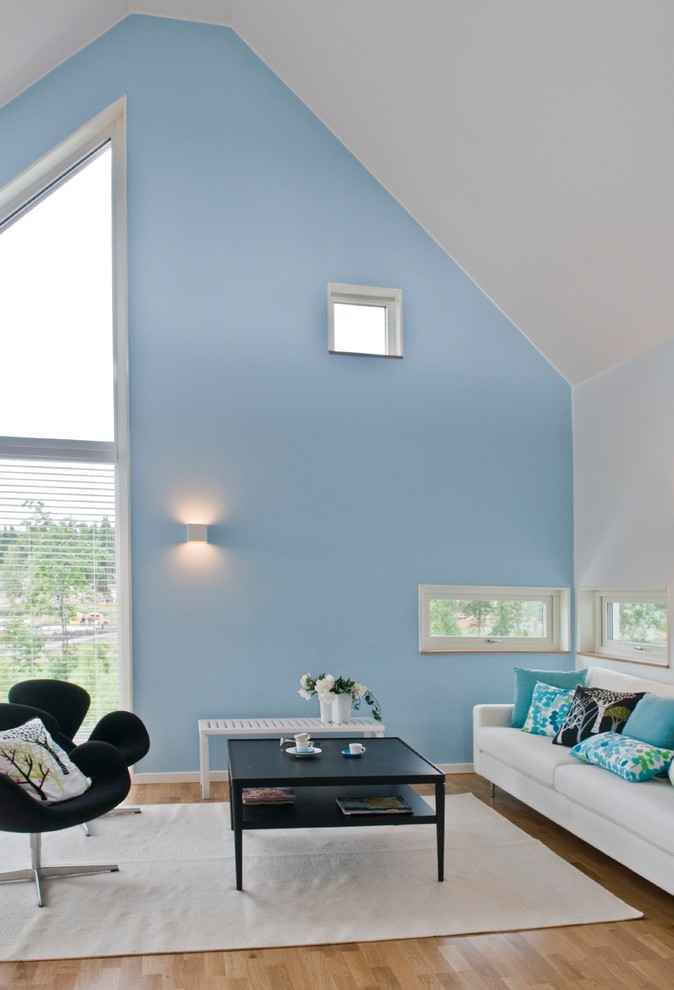 Modelo de salón contemporáneo de tamaño medio sin chimenea y televisor con paredes azules y suelo de madera en tonos medios