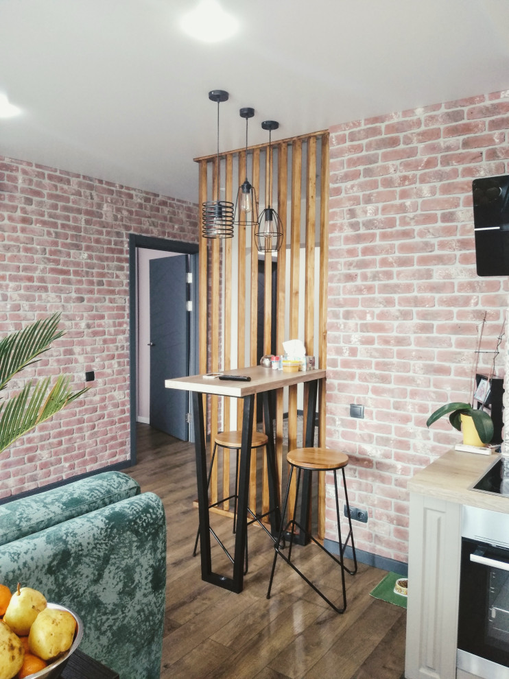 Стильный дизайн: маленькая открытая гостиная комната в современном стиле с бежевыми стенами, полом из ламината и телевизором на стене для на участке и в саду - последний тренд