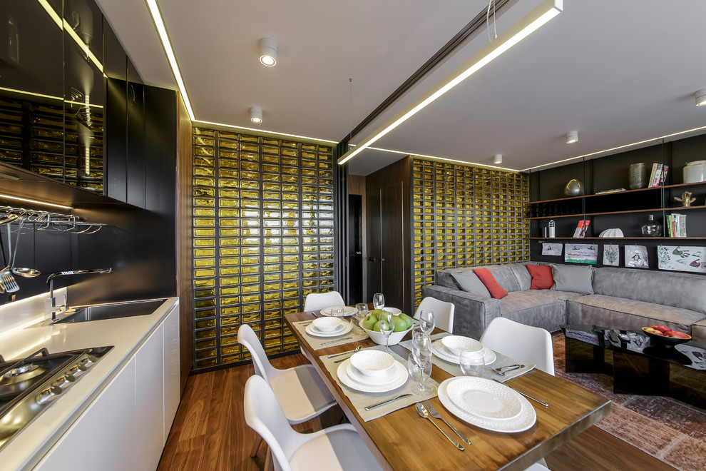 Свежая идея для дизайна: парадная, изолированная, объединенная гостиная комната среднего размера в современном стиле с черными стенами, полом из ламината, отдельно стоящим телевизором и коричневым полом - отличное фото интерьера