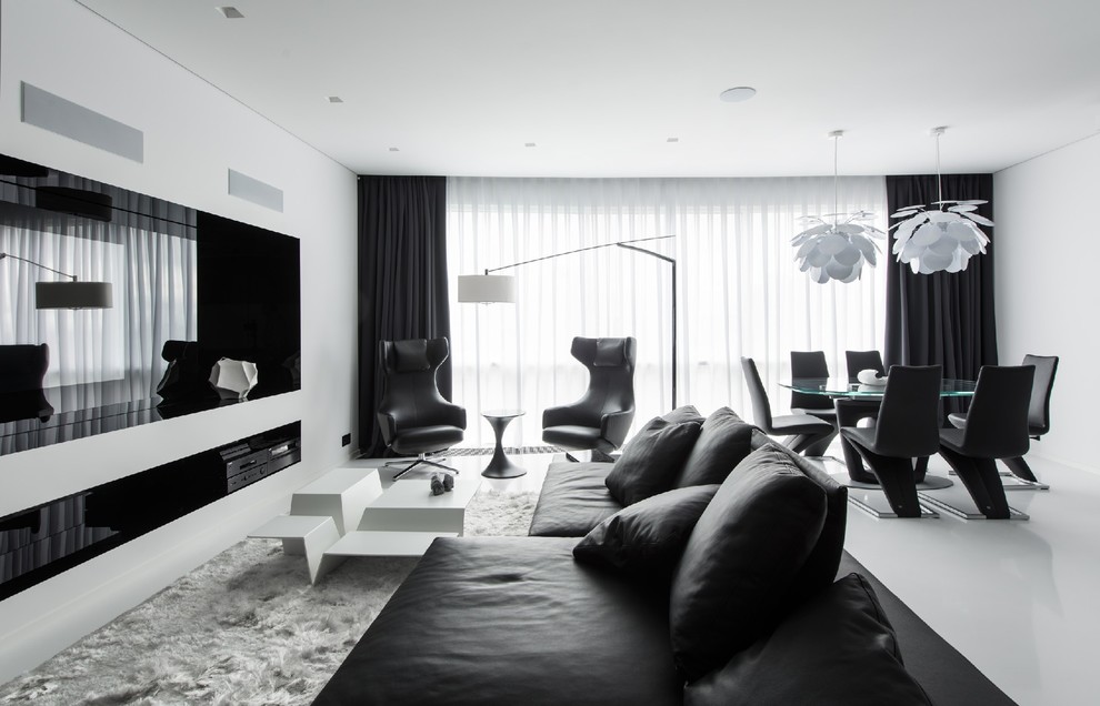 Réalisation d'un salon design ouvert avec une salle de réception, un mur blanc et un téléviseur encastré.