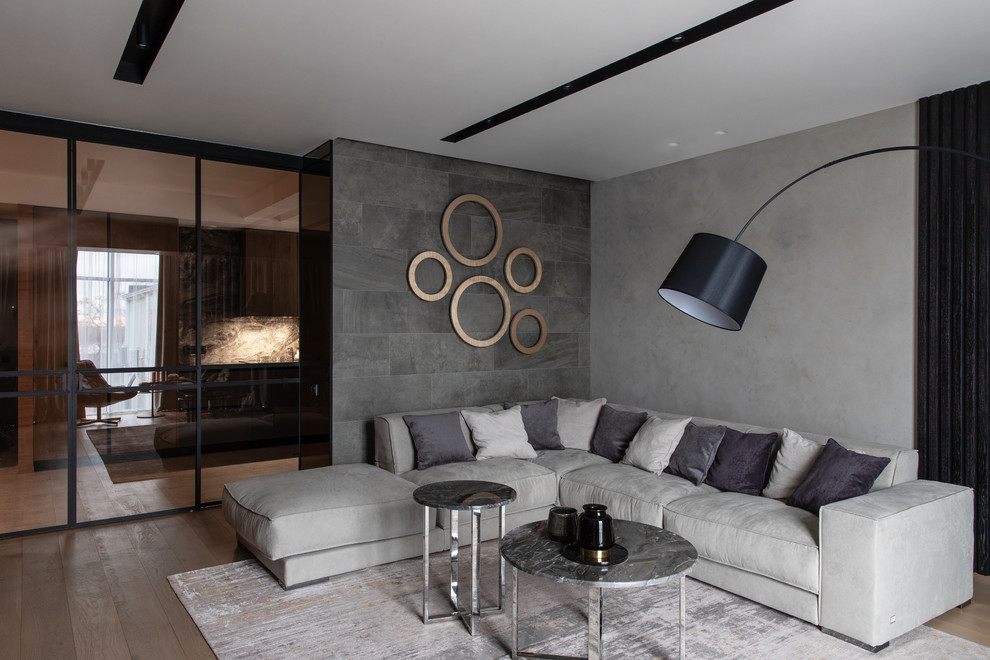 Idee per un grande soggiorno minimal con pareti grigie e pavimento in legno massello medio