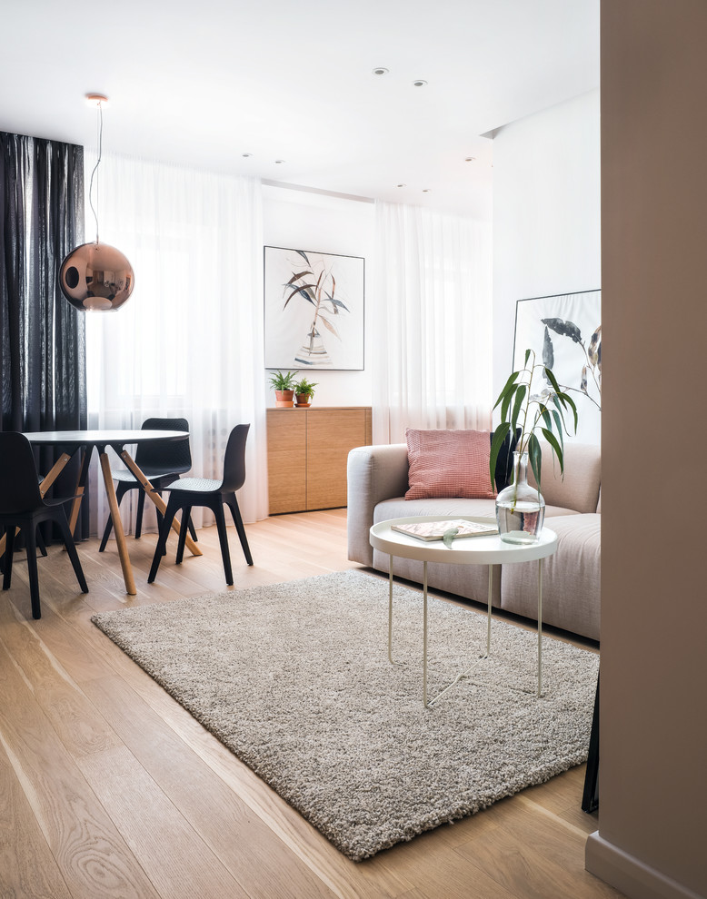 Свежая идея для дизайна: объединенная гостиная комната в современном стиле с белыми стенами, светлым паркетным полом, бежевым полом и тюлем на окнах - отличное фото интерьера