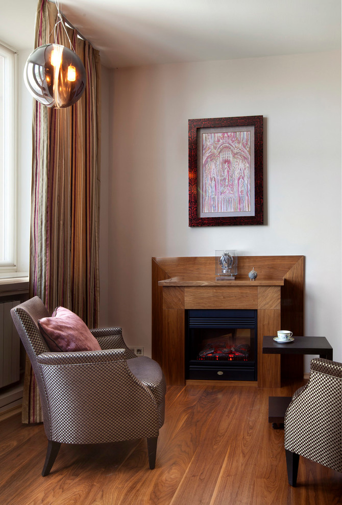 Réalisation d'un grand salon design avec parquet clair, un manteau de cheminée en bois, un mur blanc et une cheminée standard.