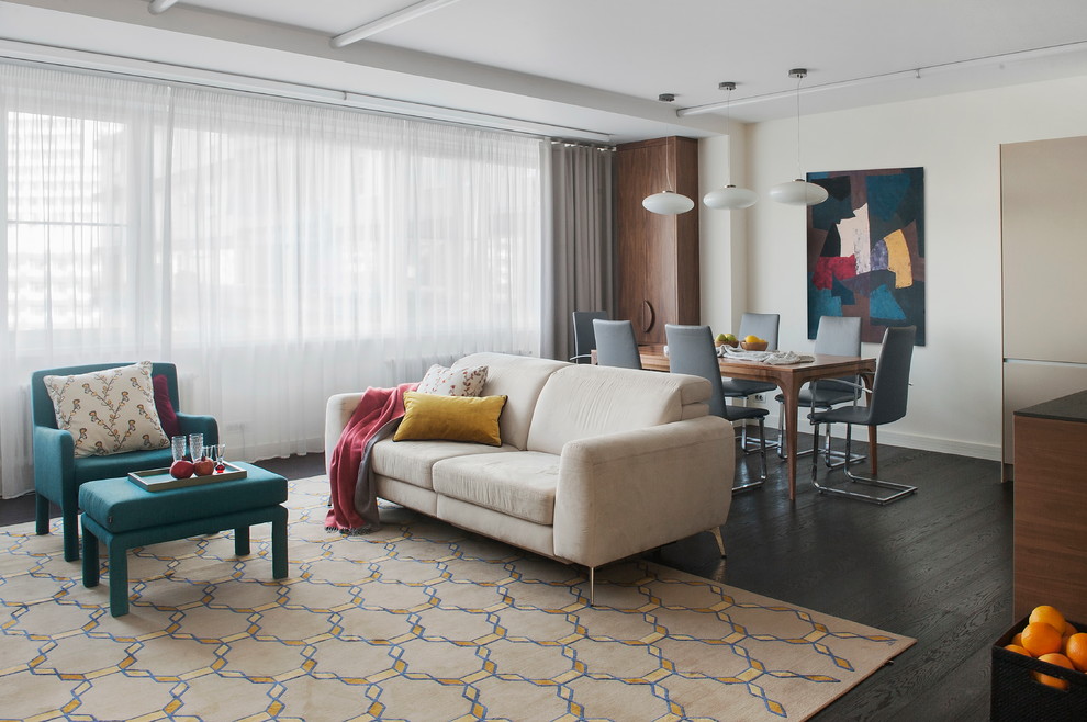 Immagine di un grande soggiorno minimal aperto con pareti beige, parquet scuro e pavimento nero