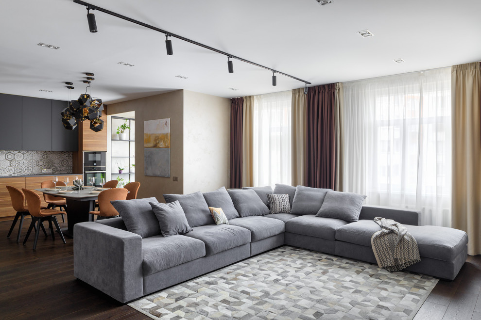 Idee per un grande soggiorno design aperto con pareti beige, parquet scuro e pavimento marrone