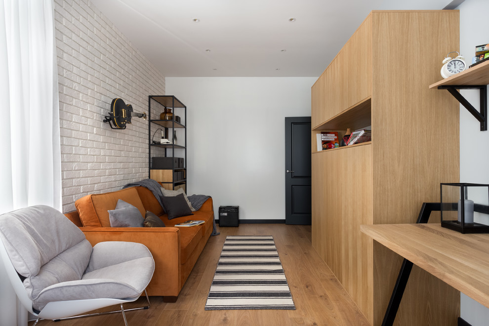 Modelo de salón cerrado nórdico pequeño sin chimenea y televisor con paredes blancas, suelo laminado y suelo marrón
