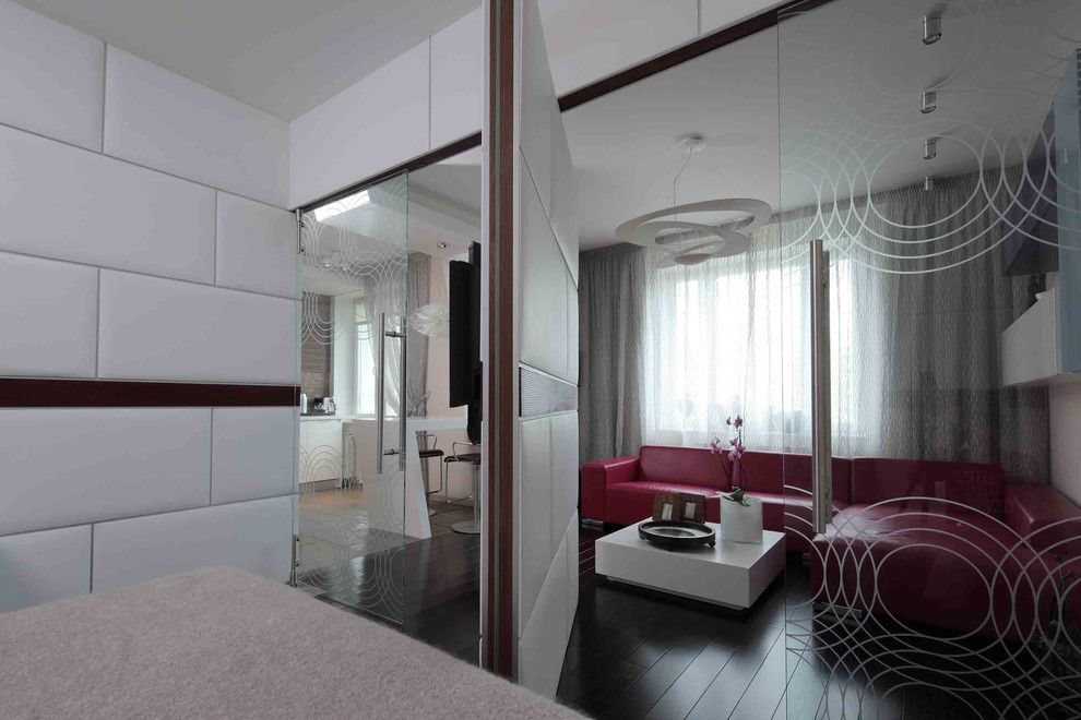 Идея дизайна: открытая гостиная комната среднего размера в современном стиле с бежевыми стенами, темным паркетным полом и телевизором на стене