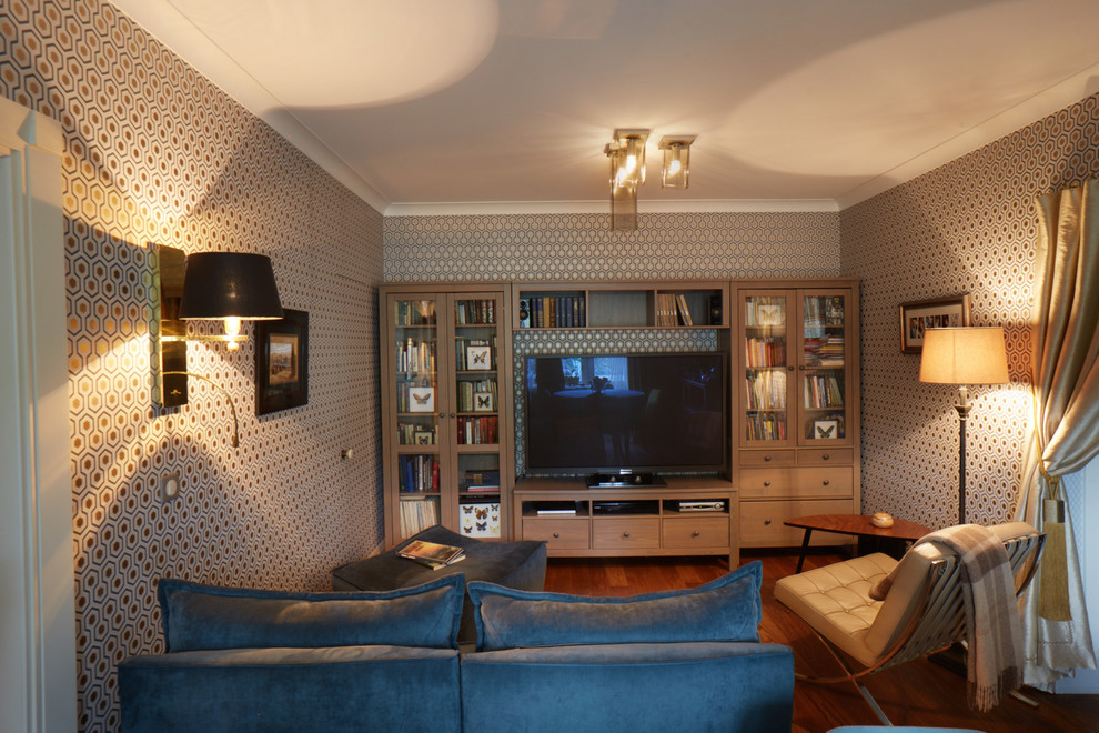 Ejemplo de biblioteca en casa abierta actual pequeña con suelo de madera en tonos medios y televisor independiente