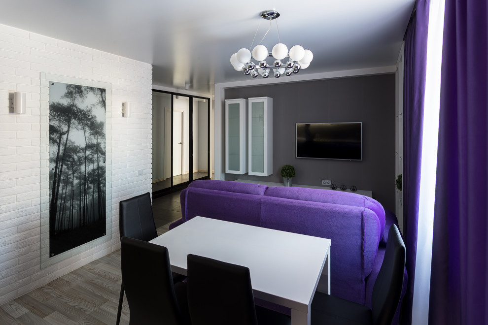 Kleines Modernes Wohnzimmer mit weißer Wandfarbe, Laminat, TV-Wand, grauem Boden und Ziegelwänden in Sonstige