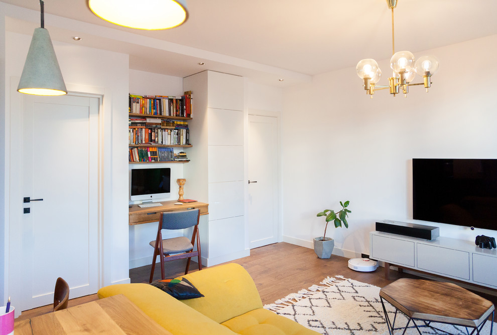 Стильный дизайн: открытая гостиная комната среднего размера в скандинавском стиле с белыми стенами, паркетным полом среднего тона, телевизором на стене и коричневым полом - последний тренд
