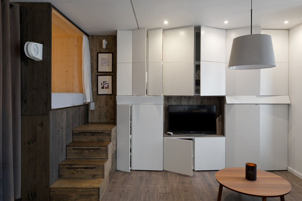 Idee per un piccolo soggiorno minimal stile loft con pareti bianche, pavimento in laminato e TV a parete