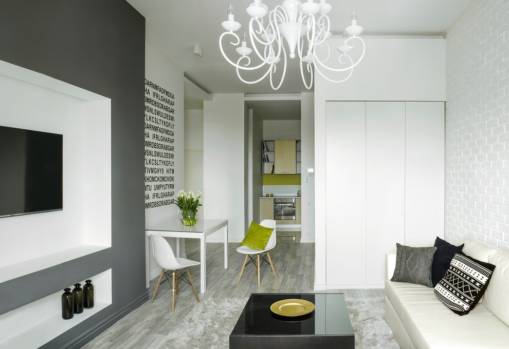 Diseño de salón abierto nórdico de tamaño medio con paredes blancas, suelo laminado y televisor colgado en la pared