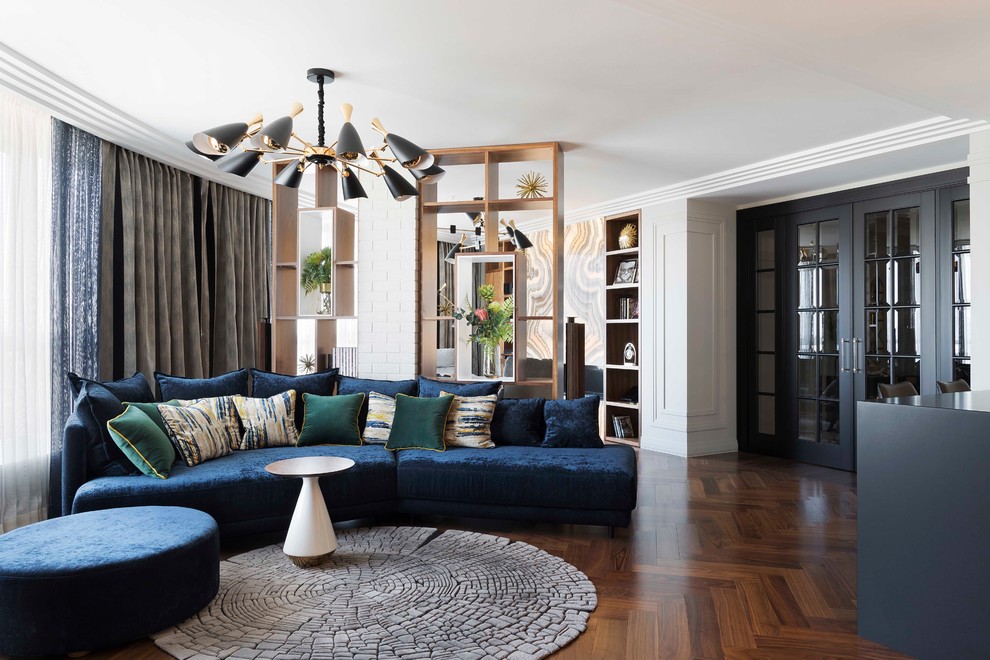 Свежая идея для дизайна: парадная гостиная комната в стиле фьюжн с белыми стенами, темным паркетным полом, коричневым полом и синим диваном - отличное фото интерьера