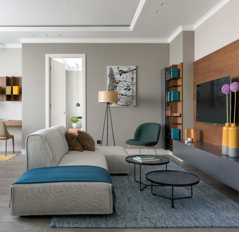 Großes, Offenes, Repräsentatives Modernes Wohnzimmer mit grauer Wandfarbe, braunem Holzboden, grauem Boden und TV-Wand in Sonstige