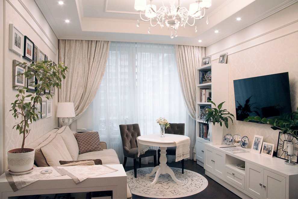 Immagine di un soggiorno design con pareti beige, TV a parete e pavimento marrone