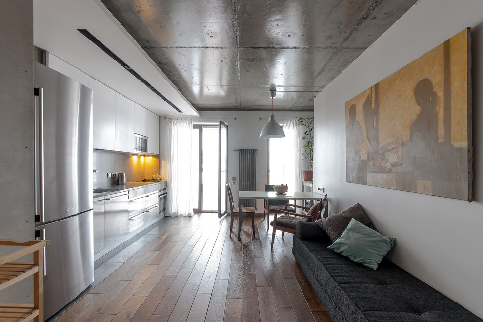 Kleines, Fernseherloses Modernes Wohnzimmer im Loft-Stil mit weißer Wandfarbe und braunem Holzboden in Sonstige